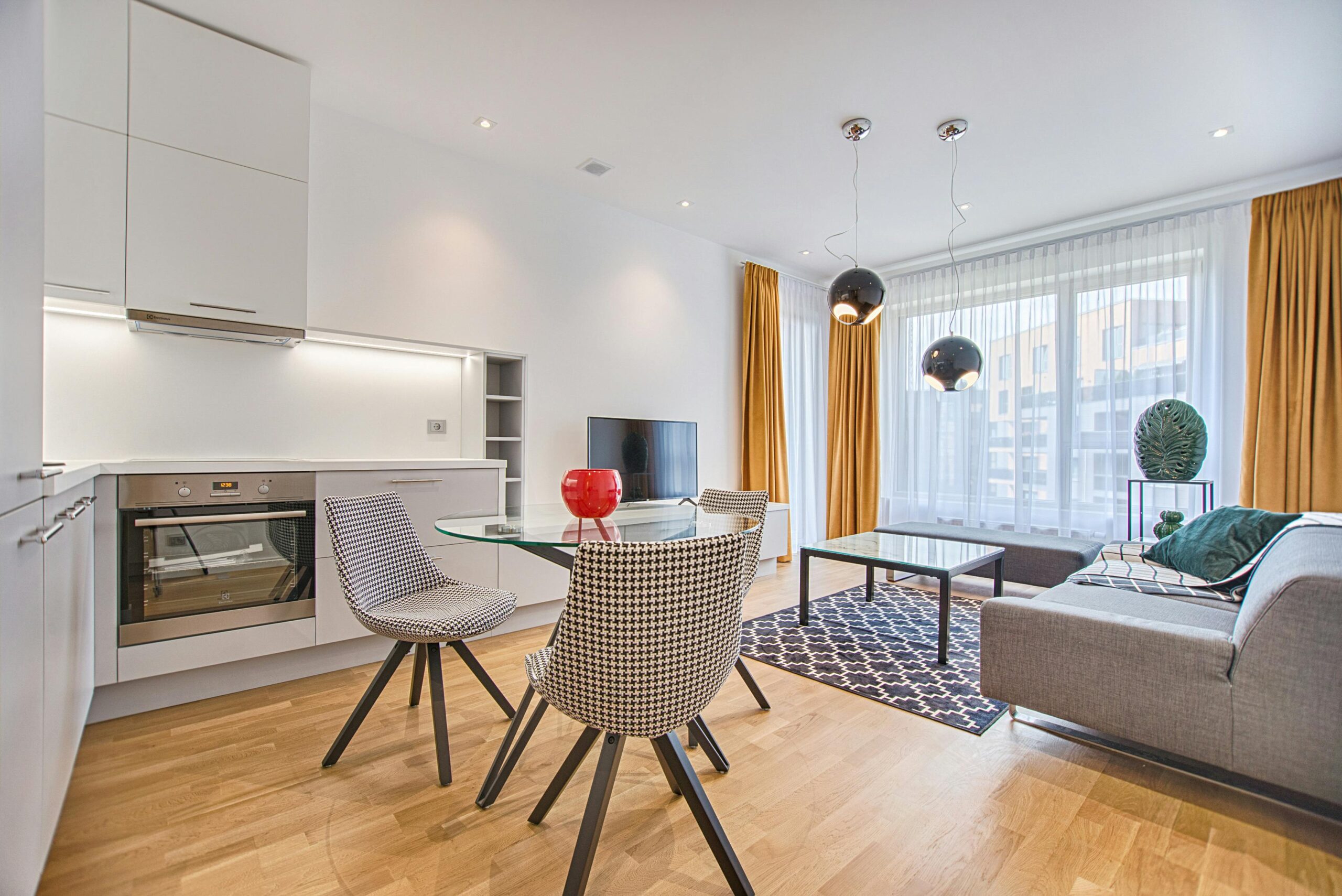 Elegant Scandinavian-style living room and kitchen featuring modern furniture and decor.